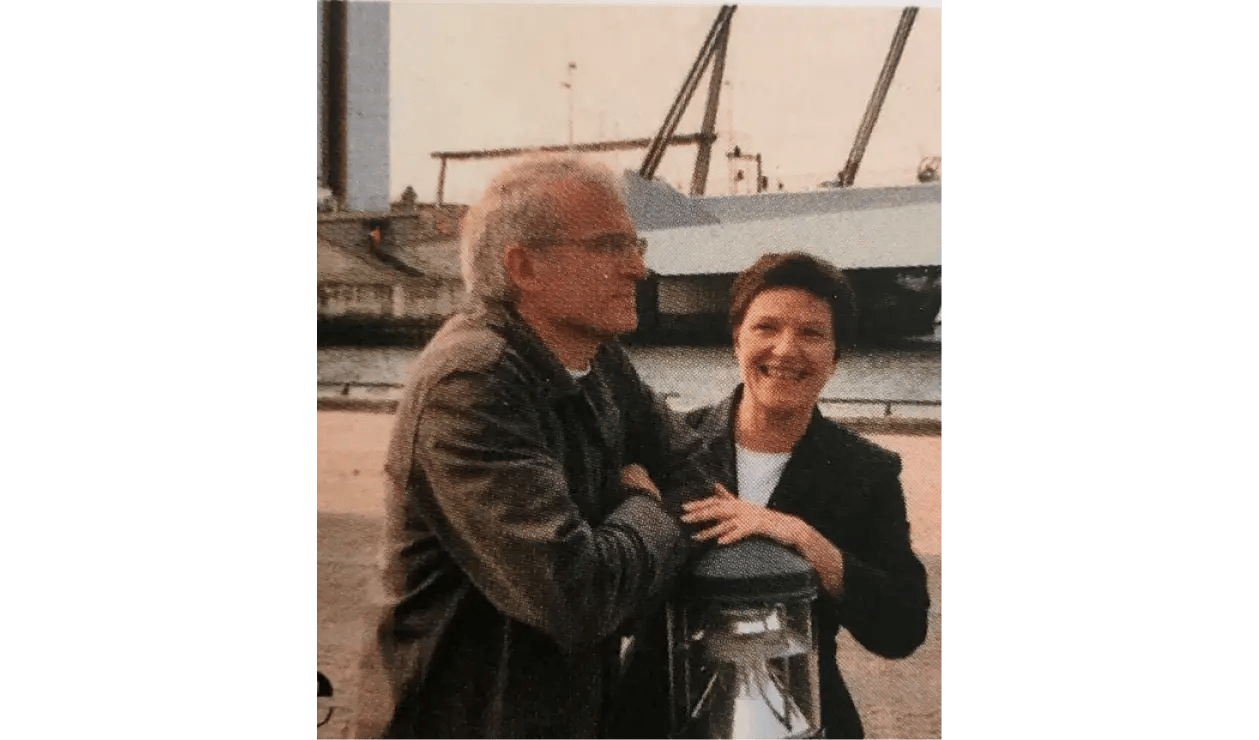 Un homme et une femme appuyés sur un poteau