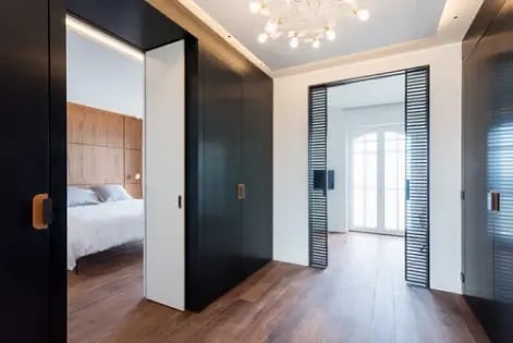 Interieur d'un appartement avec deux grandes cloisons ouvertes avec des portes coulissantes noire