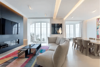 Maison avec au centre un canapé gris et un tapis coloré